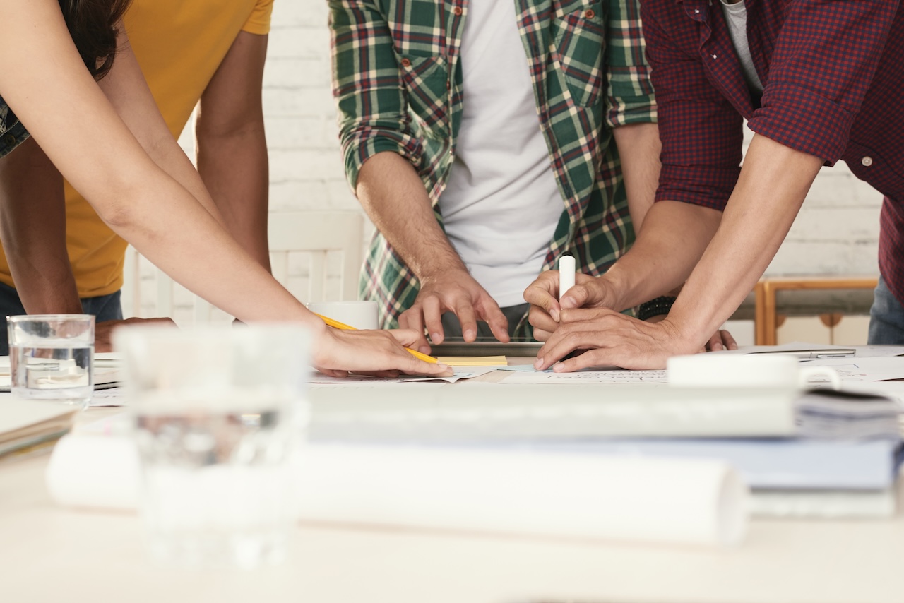 Team di progettisti al lavoro su documenti tecnici, simbolo della collaborazione nei progetti BIM e dell’uso del formato BCF per la gestione delle problematiche.